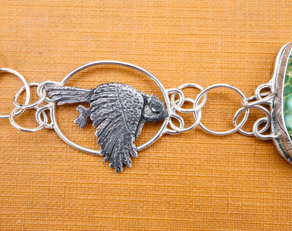 A close up view of one of the chickadees on the left side of the bracelet.