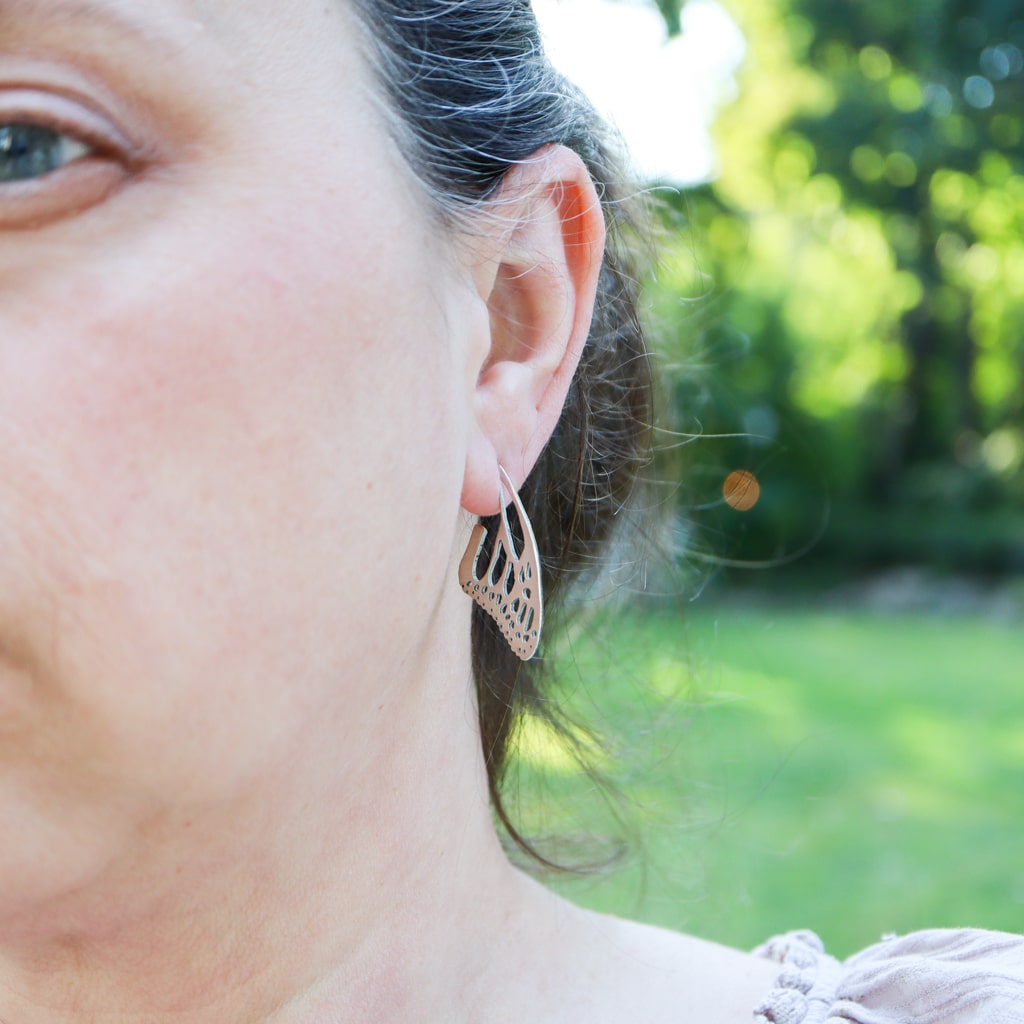 Sterling silver women's monarch butterfly wing earrings are being shown worn.