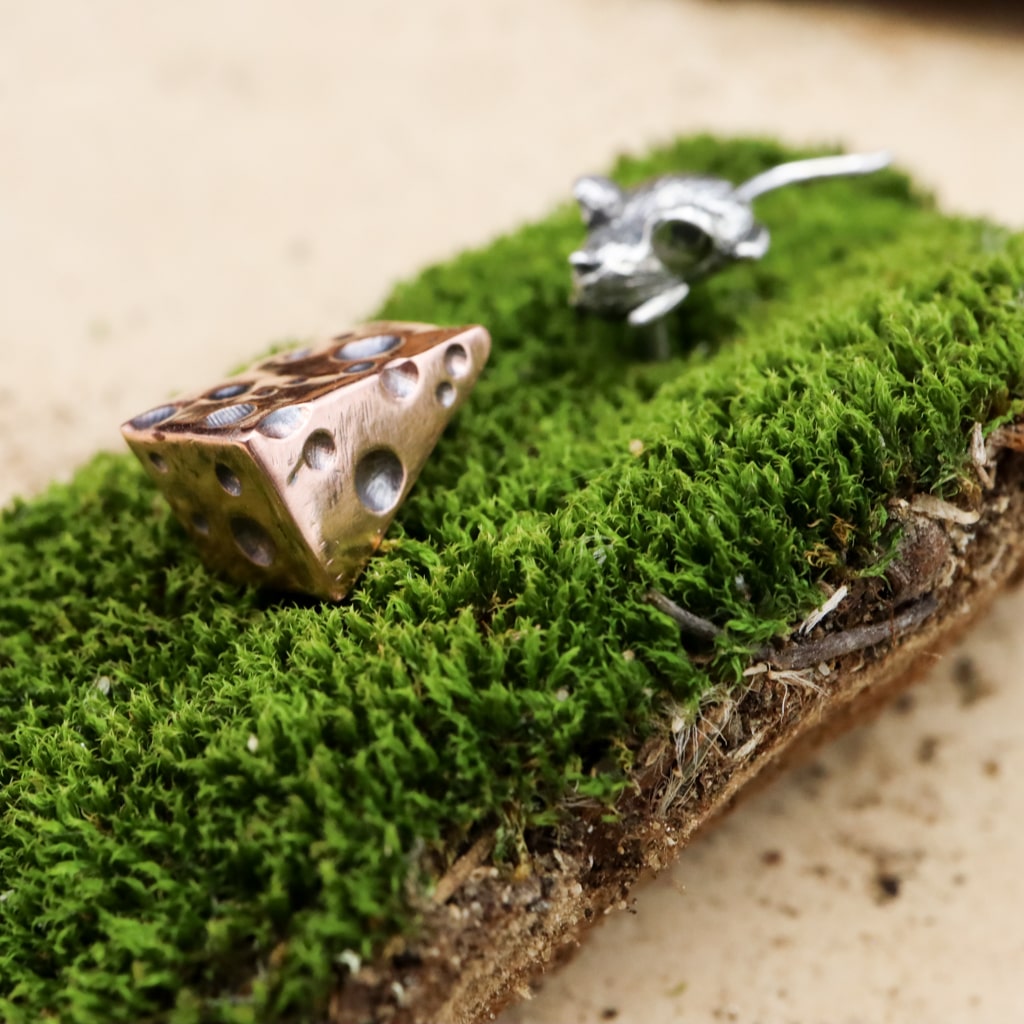 A closer angle of the tiny copper wedge of swiss cheese that is an earring.