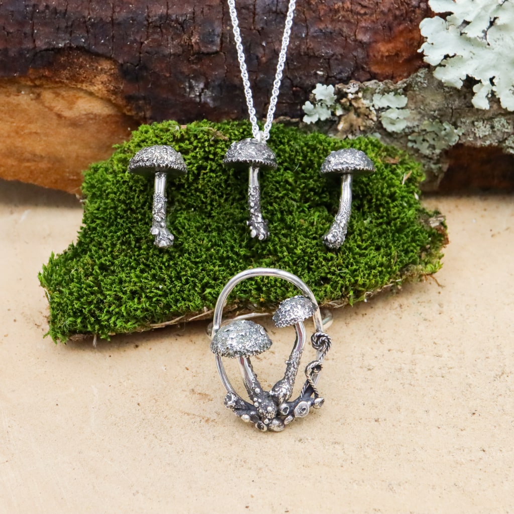 A set of mushroom earrings, necklace, and the ring are shown together.