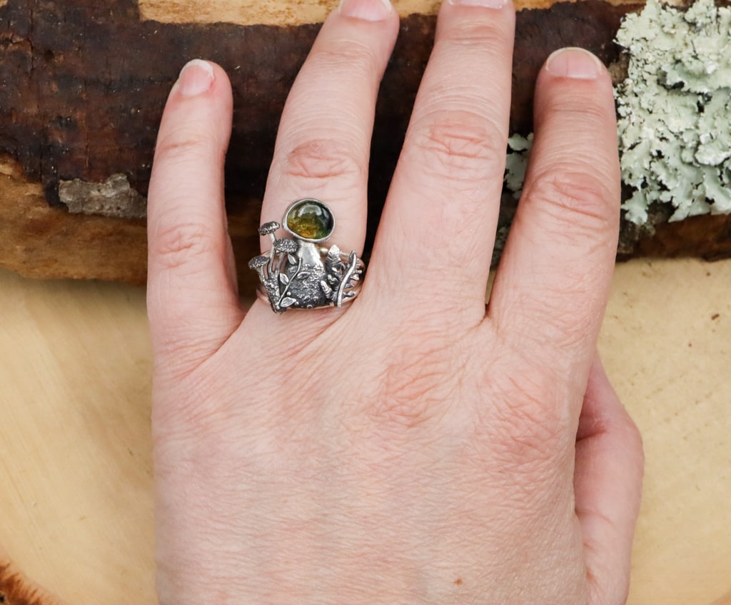 A hand is shown wearing the watermelon tourmaline gemstone mushroom ring.
