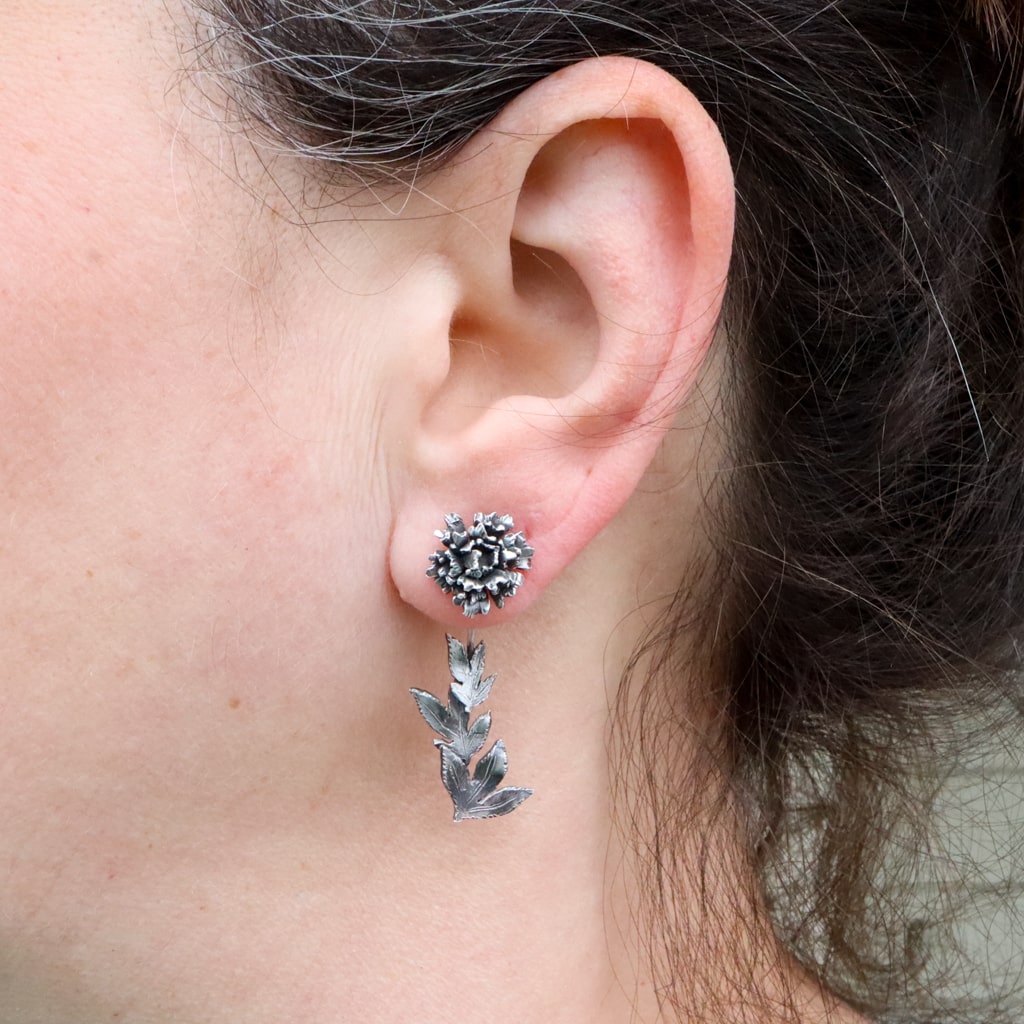 The peony flower earring dangles are shown being worn. The sterling silver floral stud earrings can also be worn with a dangling leaf stem below the earlobe.