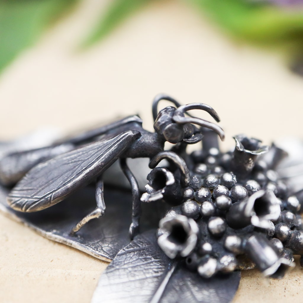 A close up of the hand carved sterling silver great black wasp.