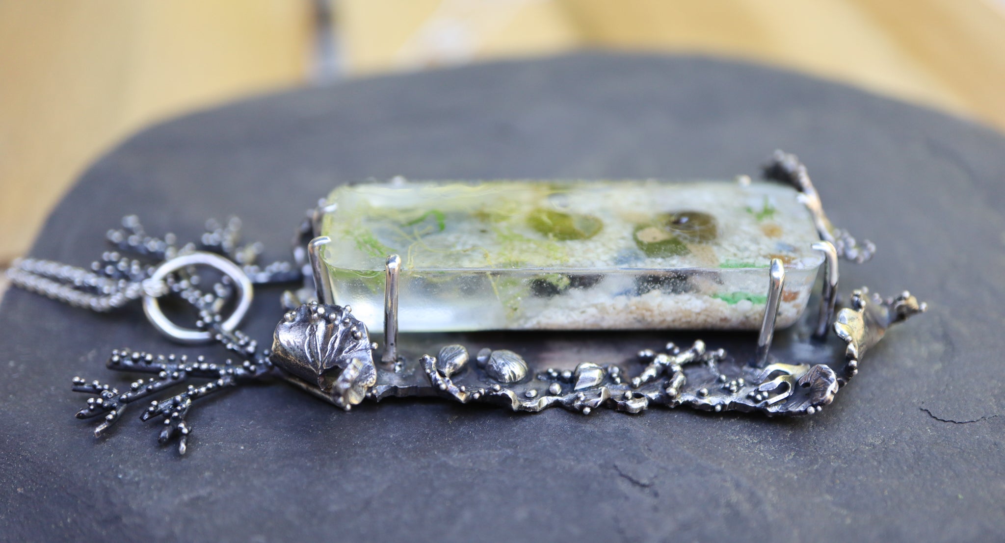 The right side of the pedant showing the resin cabochon and the texture that they piece has.