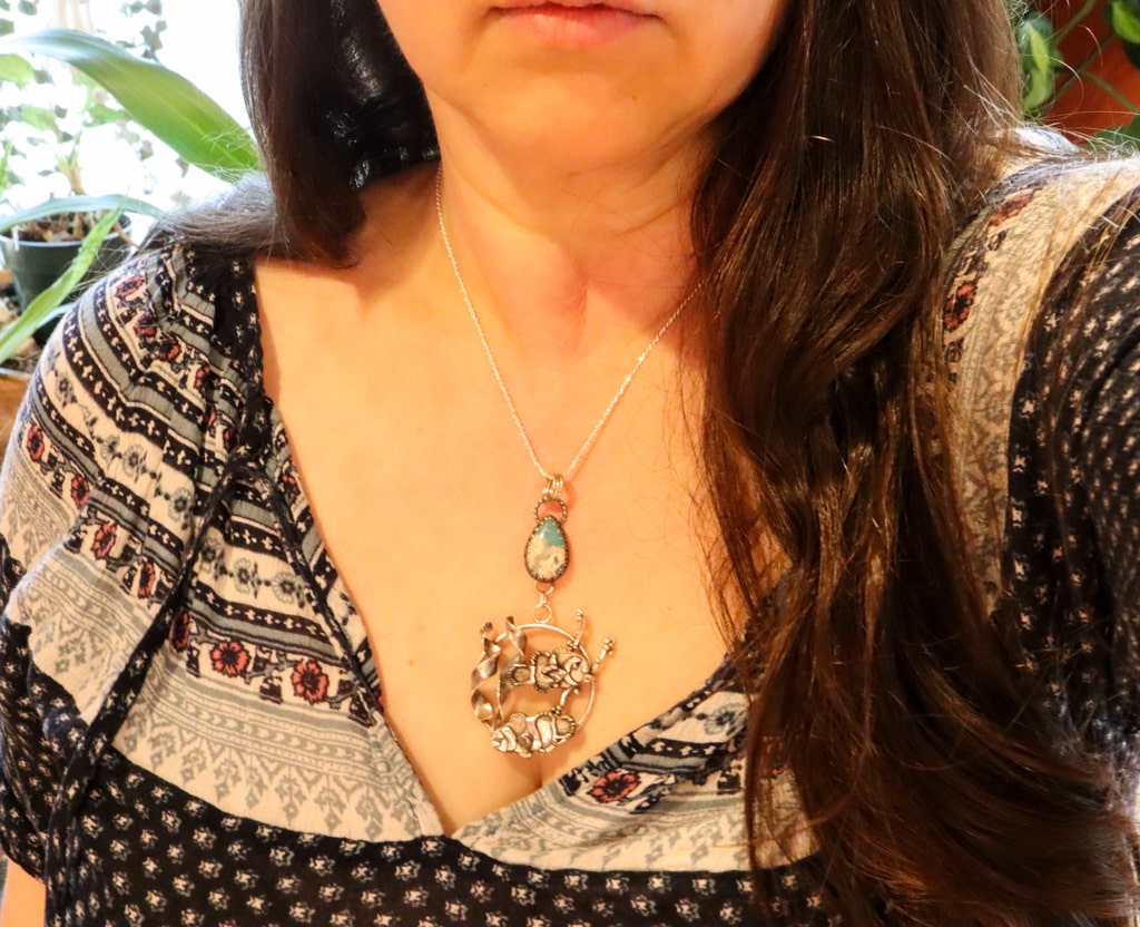 A photo of the clownfish necklace being worn by someone with a dark blue shirt.