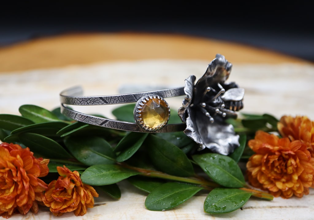 One of the rose cut yellow citrine stones. The bracelet band has been patterned using real leaves.