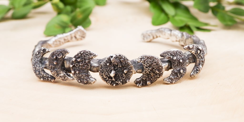 A close up of the sterling silver moon phase bracelet showing the 7 moons.