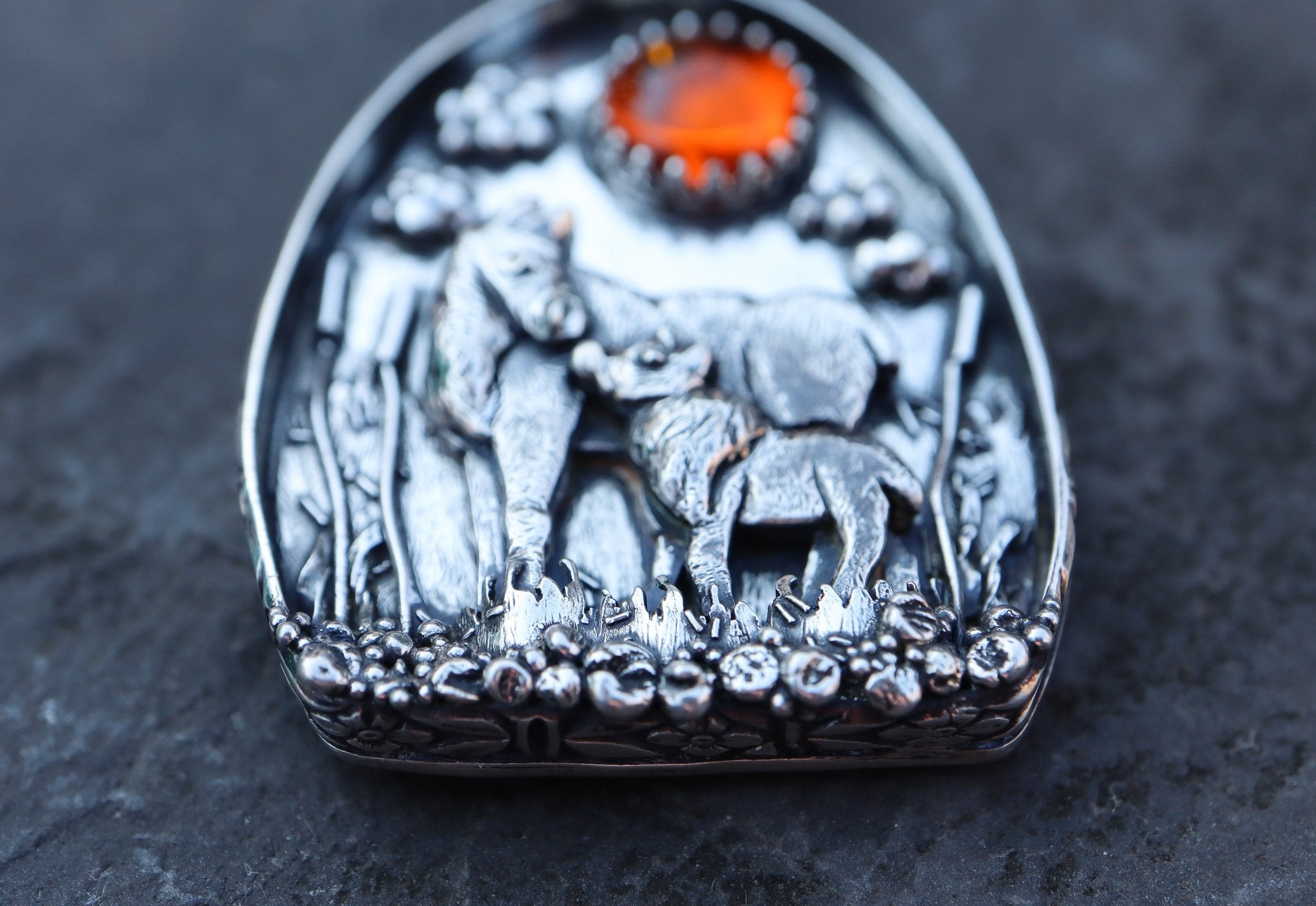The bottom view of a moose pendant show the tiny silver stones lining the edge of the piece. Made by The Striped Cat Metalworks.