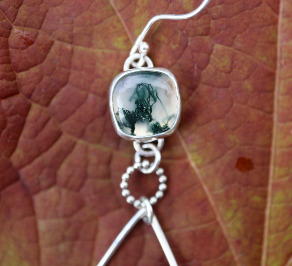A close up of one of the dark green and clean moss agate gemstones.