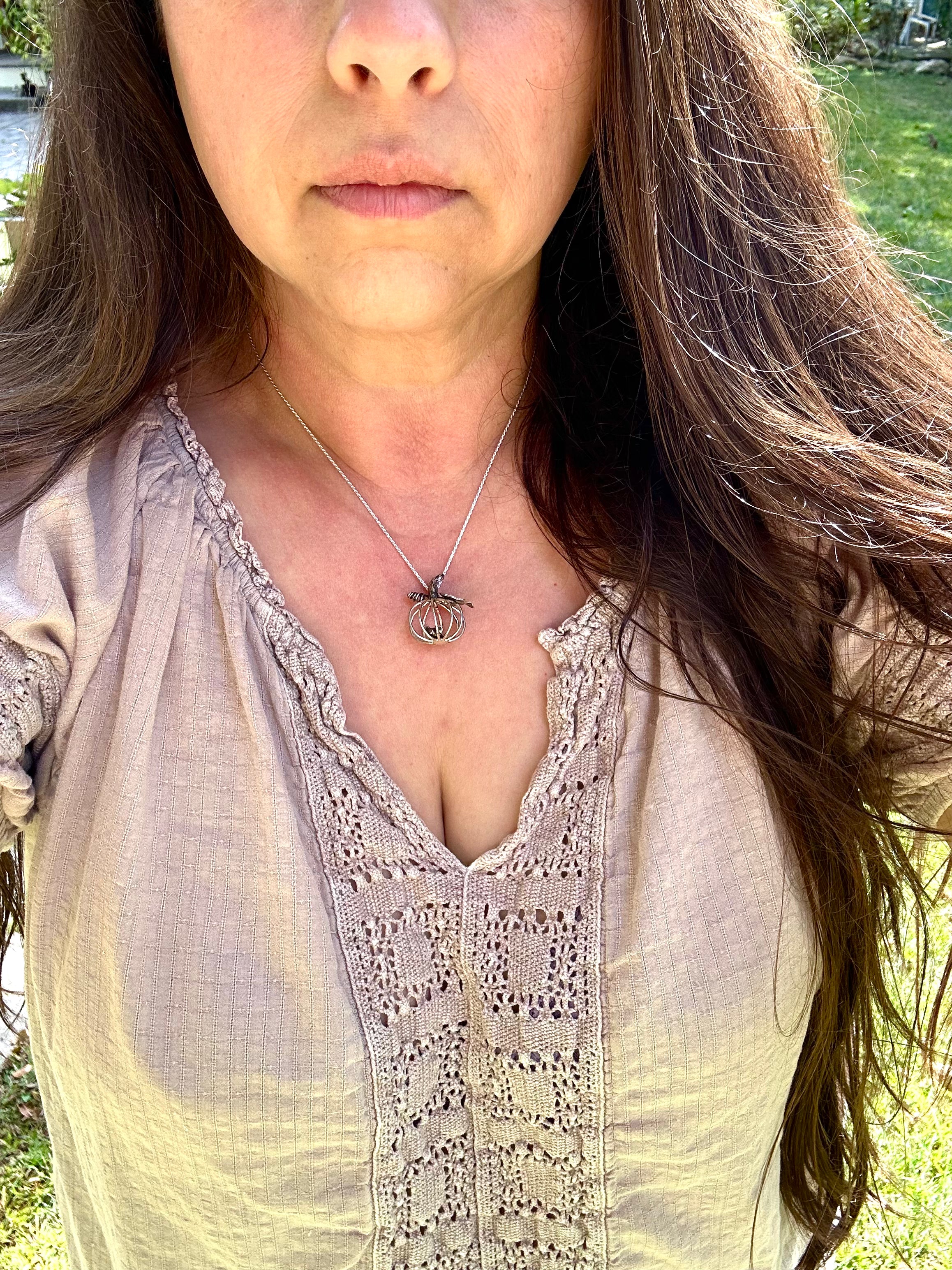Woman wearing a light-colored blouse with lace details outdoors
