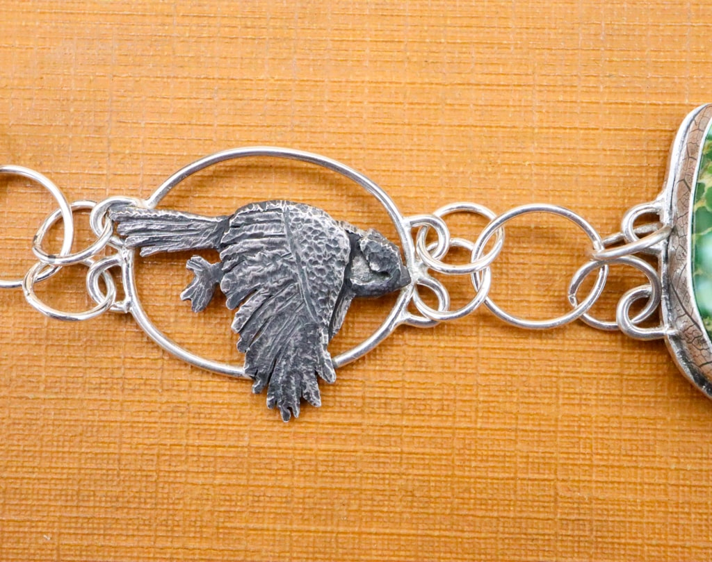 A close up view of one of the chickadees on the left side of the bracelet. 