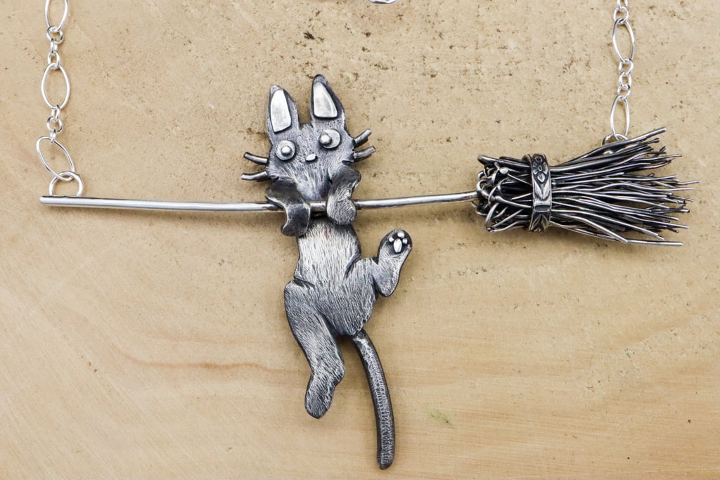 A closer view of the Kiki's Delivery Service sterling silver Jiji necklace. 