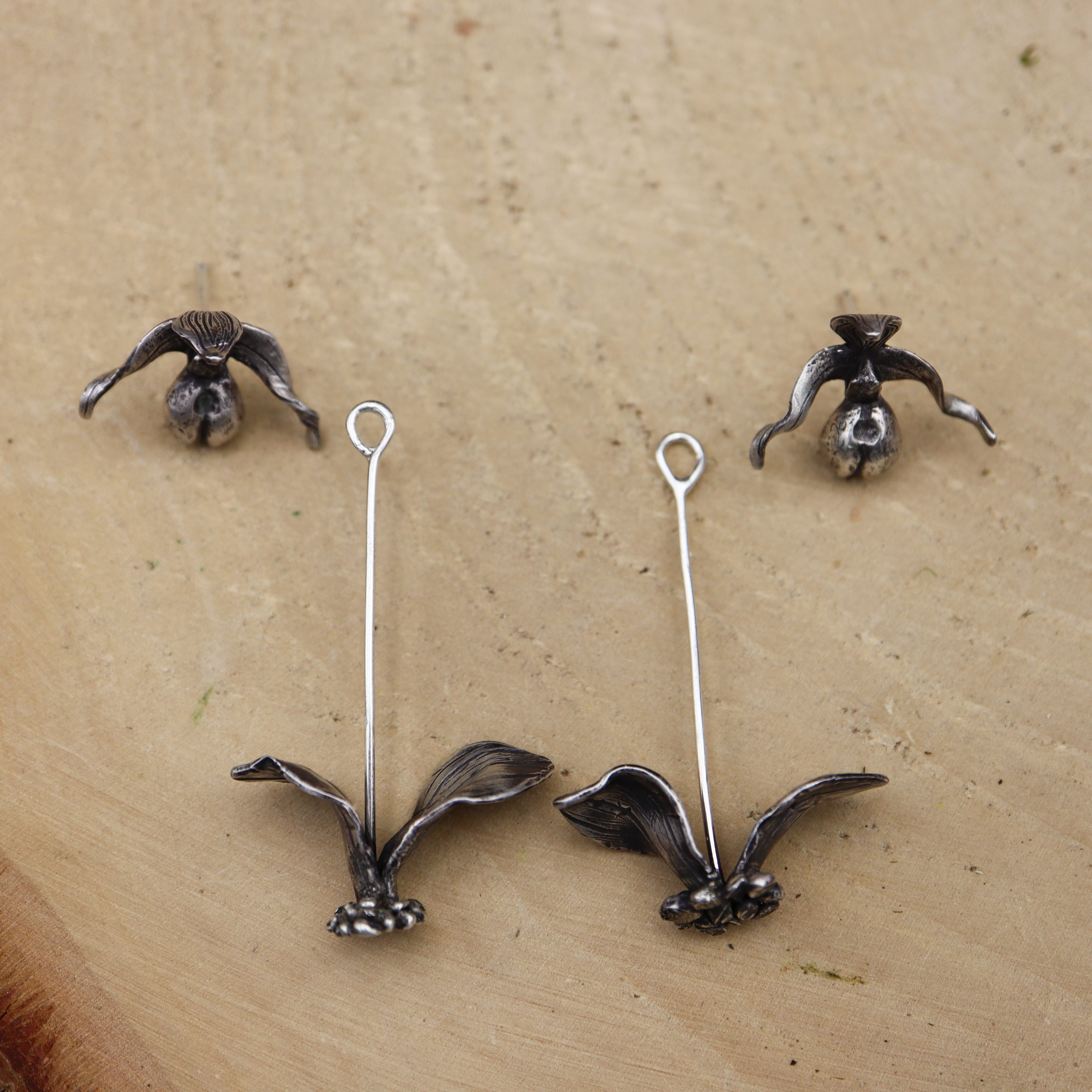 Sterling silver pink lady slipper earrings are shown in two pieces because they can be worn with the dangling leaves and stem or they can be worn just as flower studs. 
