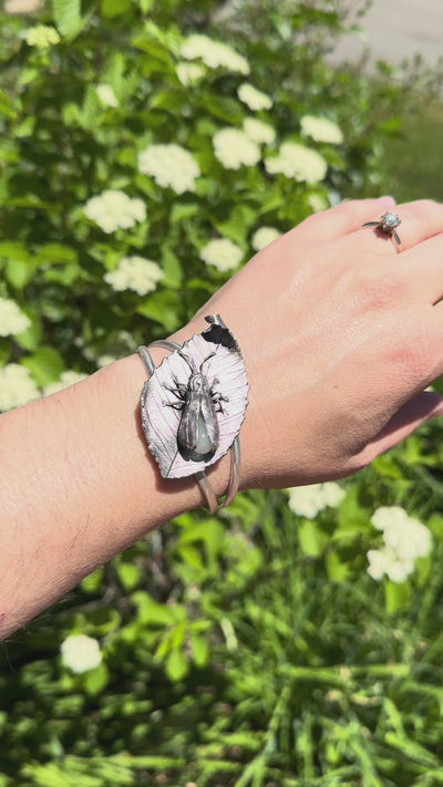 A video showing the glow in the dark sterling silver firefly bracelet being worn on a wrist. The woman wears it outdoors in the sunshine and then goes indoors with it to show the glow from the glass abdomen. 