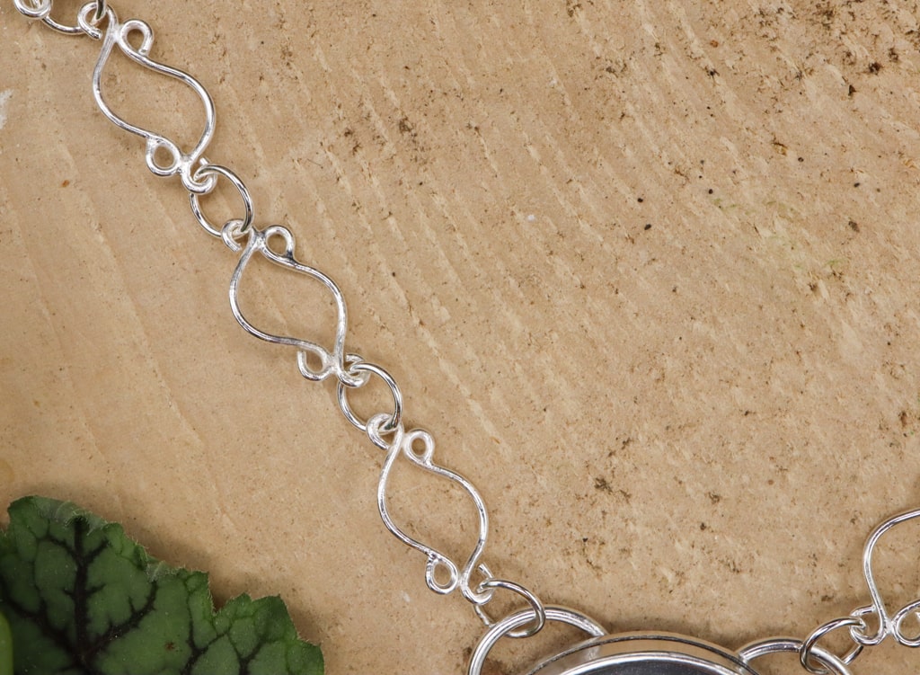 The handmade sterling silver necklace chain is made from fancy links.