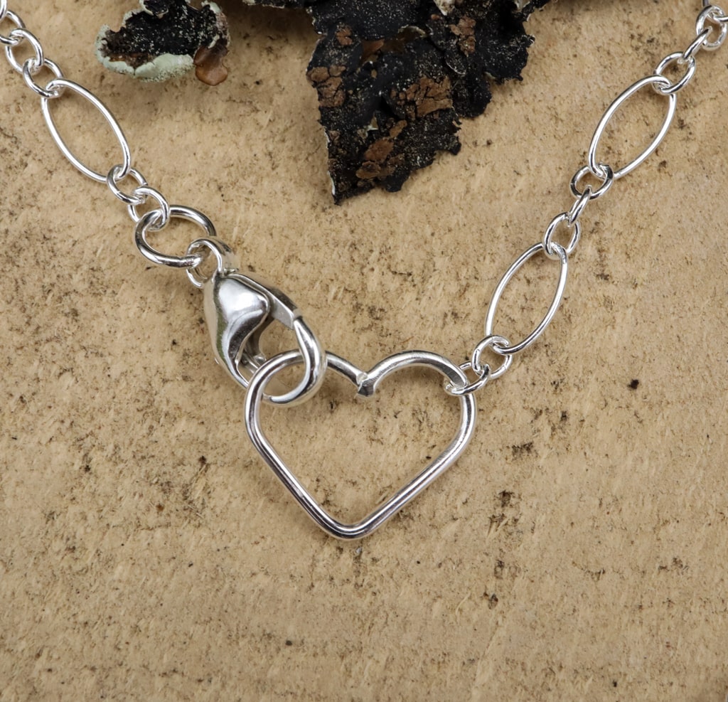 the claps of the necklace is made with a larger silver lobster claw on one side and a heart on the other to keep the necklace closed. 