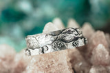 A close up of the New Hampshire White Mountains ring with tiny trees and bushes on the band.