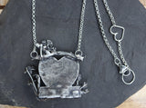 The back of the pendant showing the necklace and the heart connection to close the necklace making it shorter if needed. 