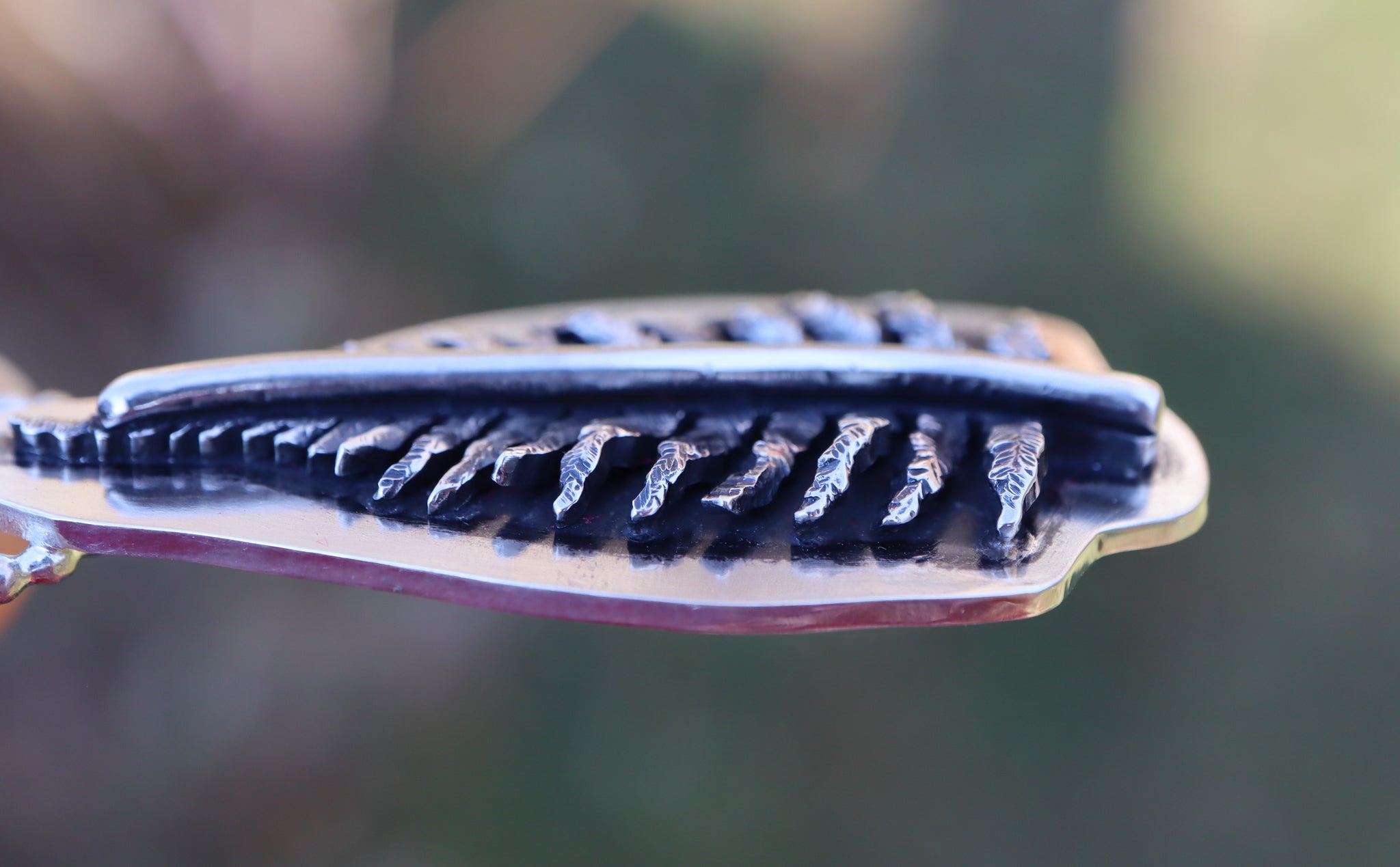 A size view of the carved sterling silver fern necklace. 