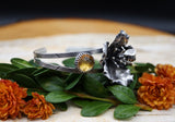 One of the rose cut yellow citrine stones. The bracelet band has been patterned using real leaves. 