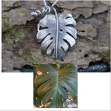 A photo of a real monstera deliciosa leaf that I made a sterling silver leaf to exactly replicate so that it can be worn on a necklace. 