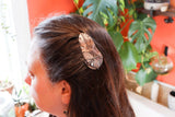 A sterling silver milkweed tussock moth hair comb being worn. 