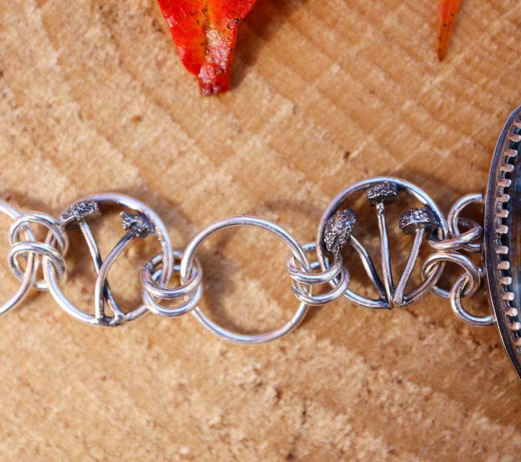 The left side of the bracelet showing the small bracelet links with mushrooms within them. 