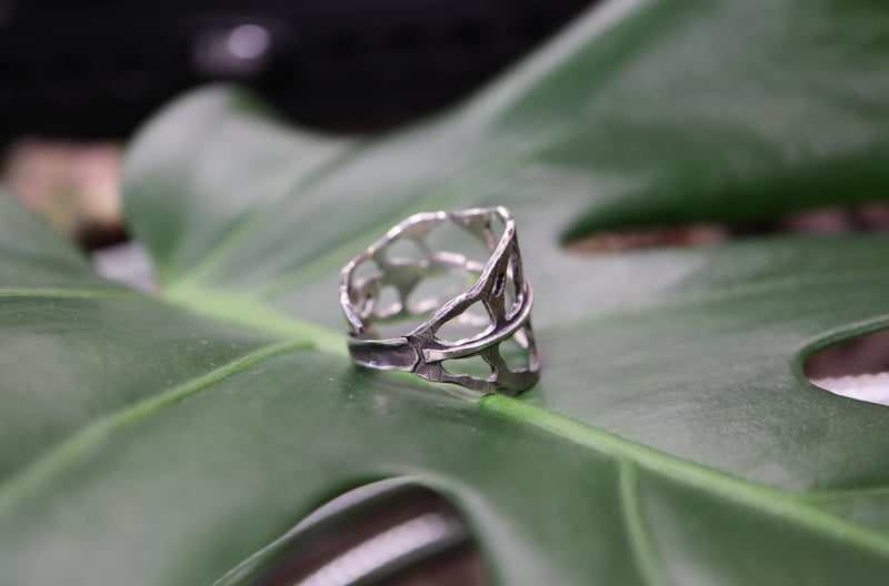 The side view of a handmade sterling silver monstera obliqua leaf.