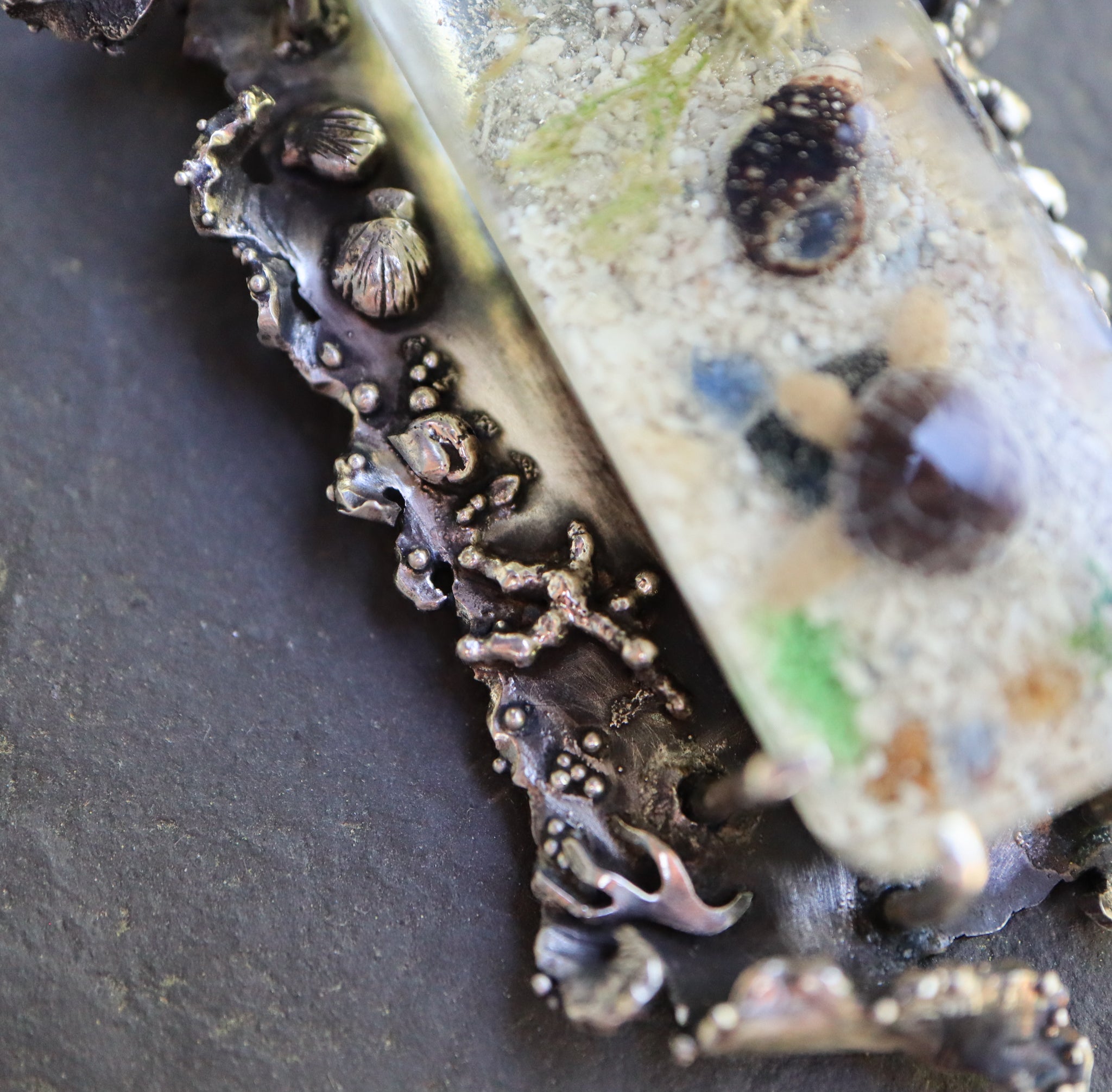 A close up of the tiny silver stones and seaweed. 