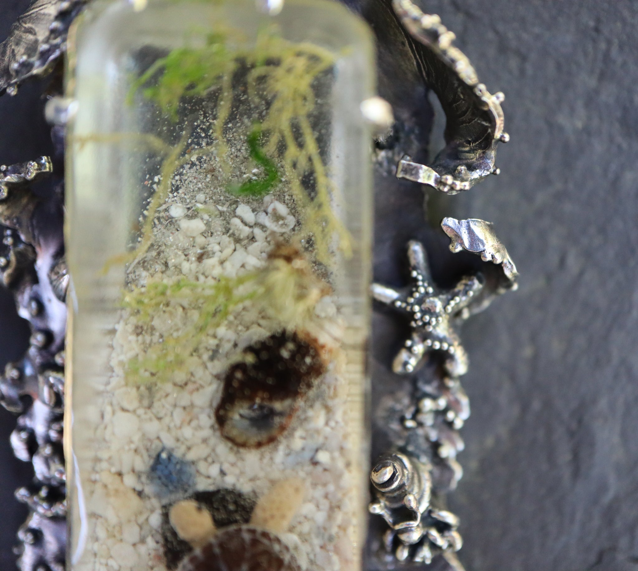 A close up photo of where the sand ends within the resin piece and a closer photo of the starfish. 