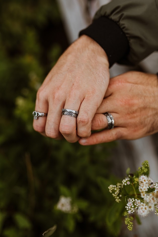 Both of the wedding rings made in the mountain range design shown being worn. 